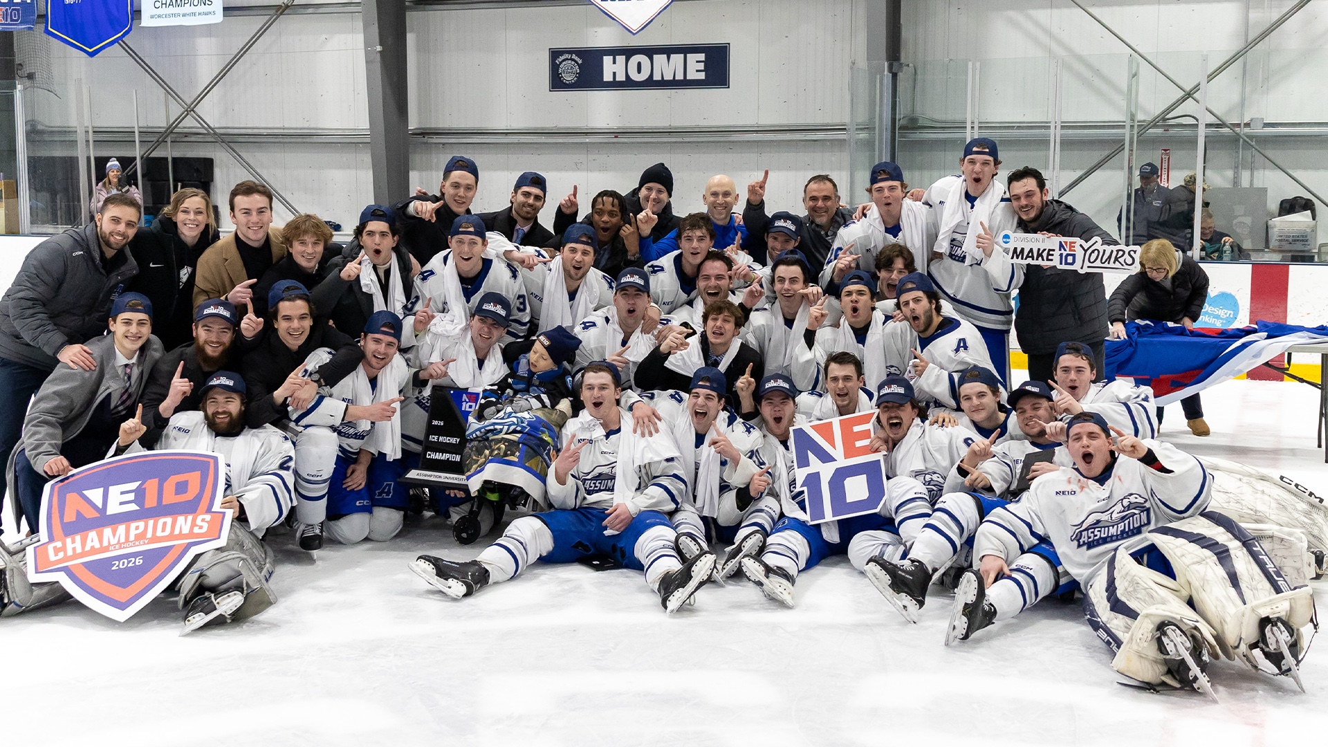 Assumption University hockey players and supporters celebrating the 2026 NE10 championship on the ice